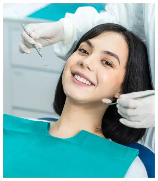Young woman smiling during dental examination in modern dental office setting.