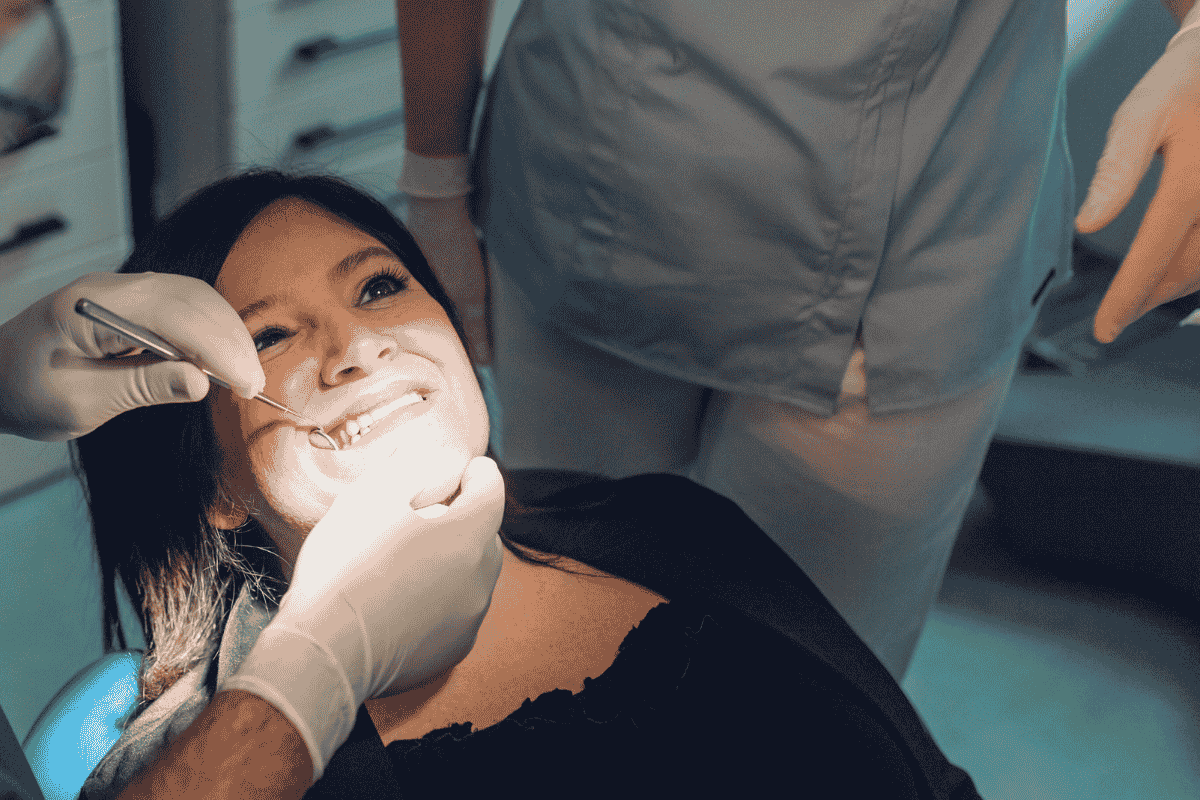dentist checking patients teeth with dental tool