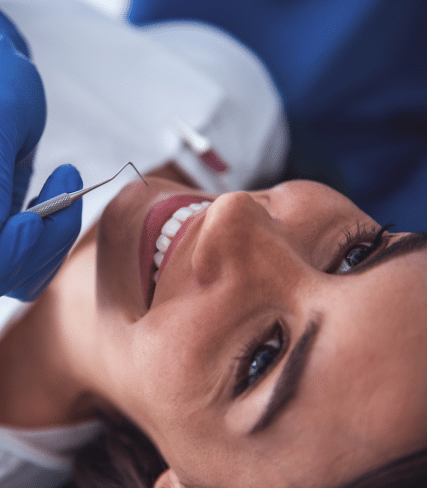 Patients with beautiful smile having teeth checked by dentist
