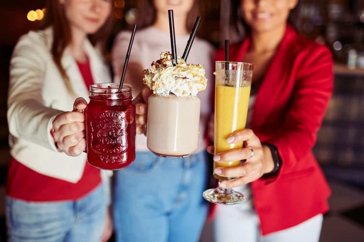 three women toasting with three sugary drinks